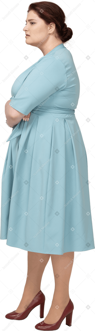 Donna in abito blu in posa con le braccia incrociate