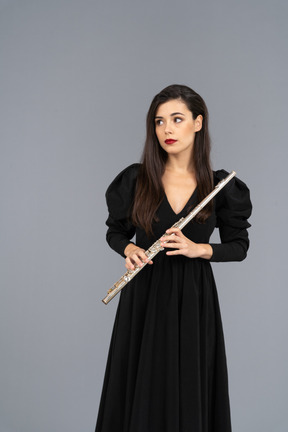 Front view of a young lady in black dress holding flute