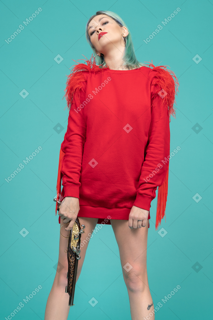 Confident young woman standing with a gun