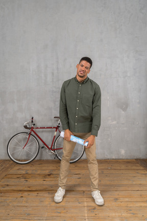 A man standing next to a bike on a wooden floor