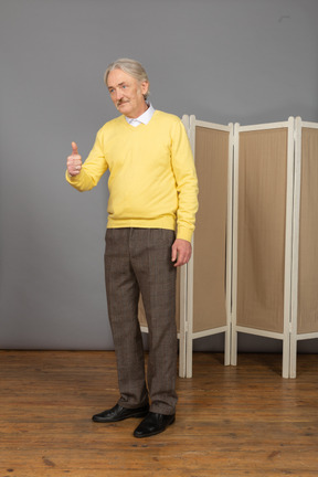 Vista laterale di un uomo anziano che mostra il pollice in su