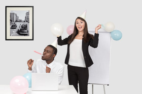 A woman in a party hat standing next to a man