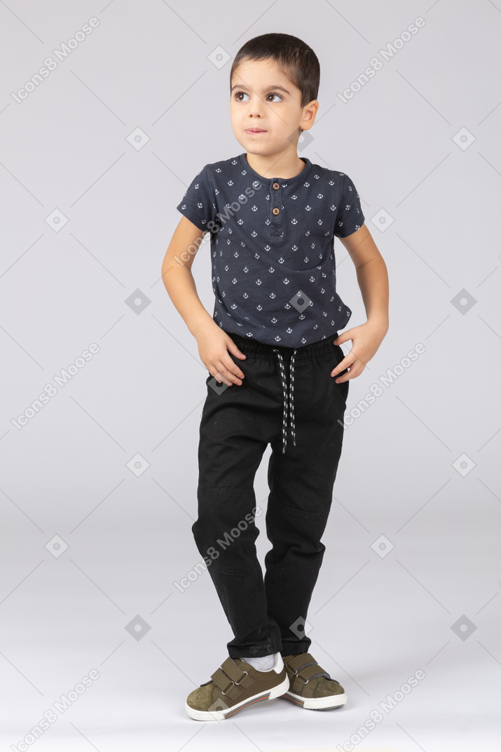 Front view of a cute boy posing with hands on hips