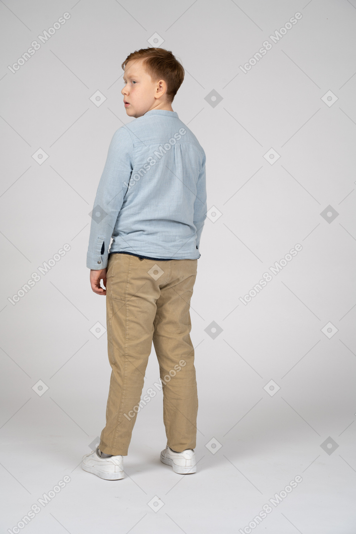 Rear view of a boy in casual clothes looking aside