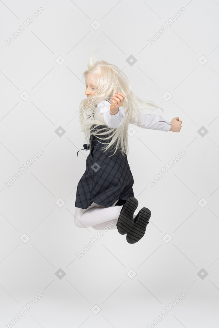 Back view of a schoolgirl jumping up