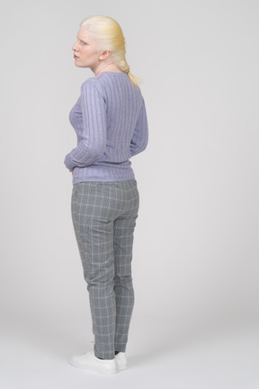Three-quarter back view of a blonde woman looking aside