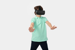 Boy in virtual reality set pushing something invisible away