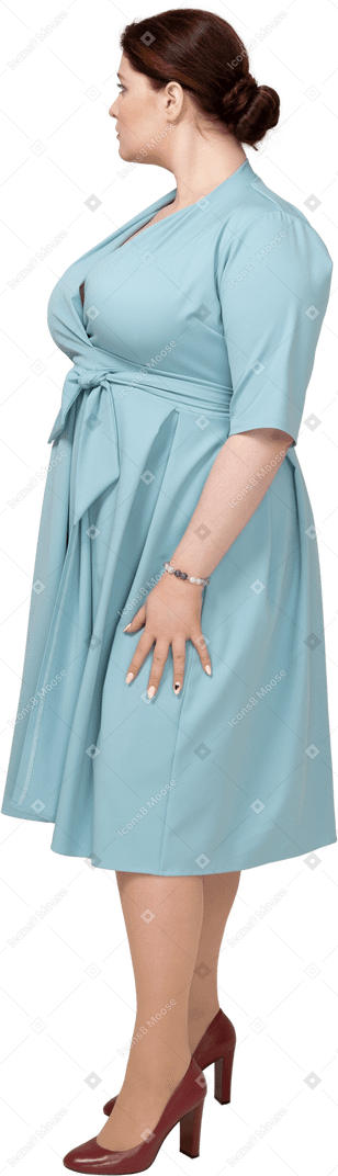 Femme en robe bleue debout de profil