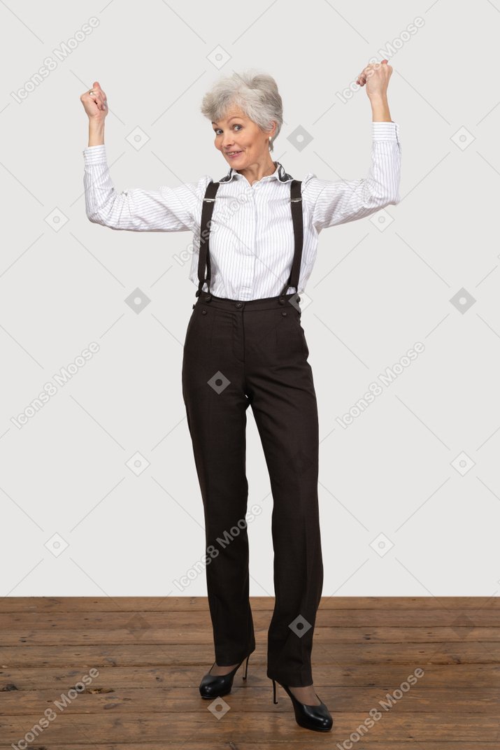 Formally dressed woman celebrating with her hands up