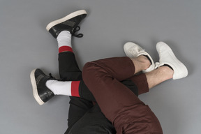 Flat lay of two pairs of legs intertwined