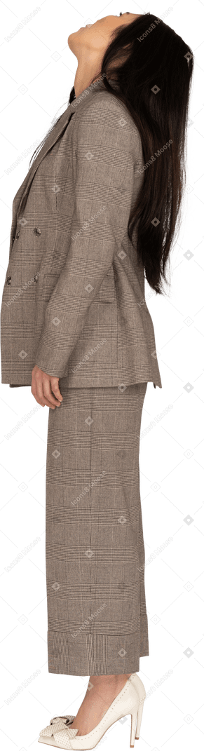 Side view of a young lady in brown business suit raising head