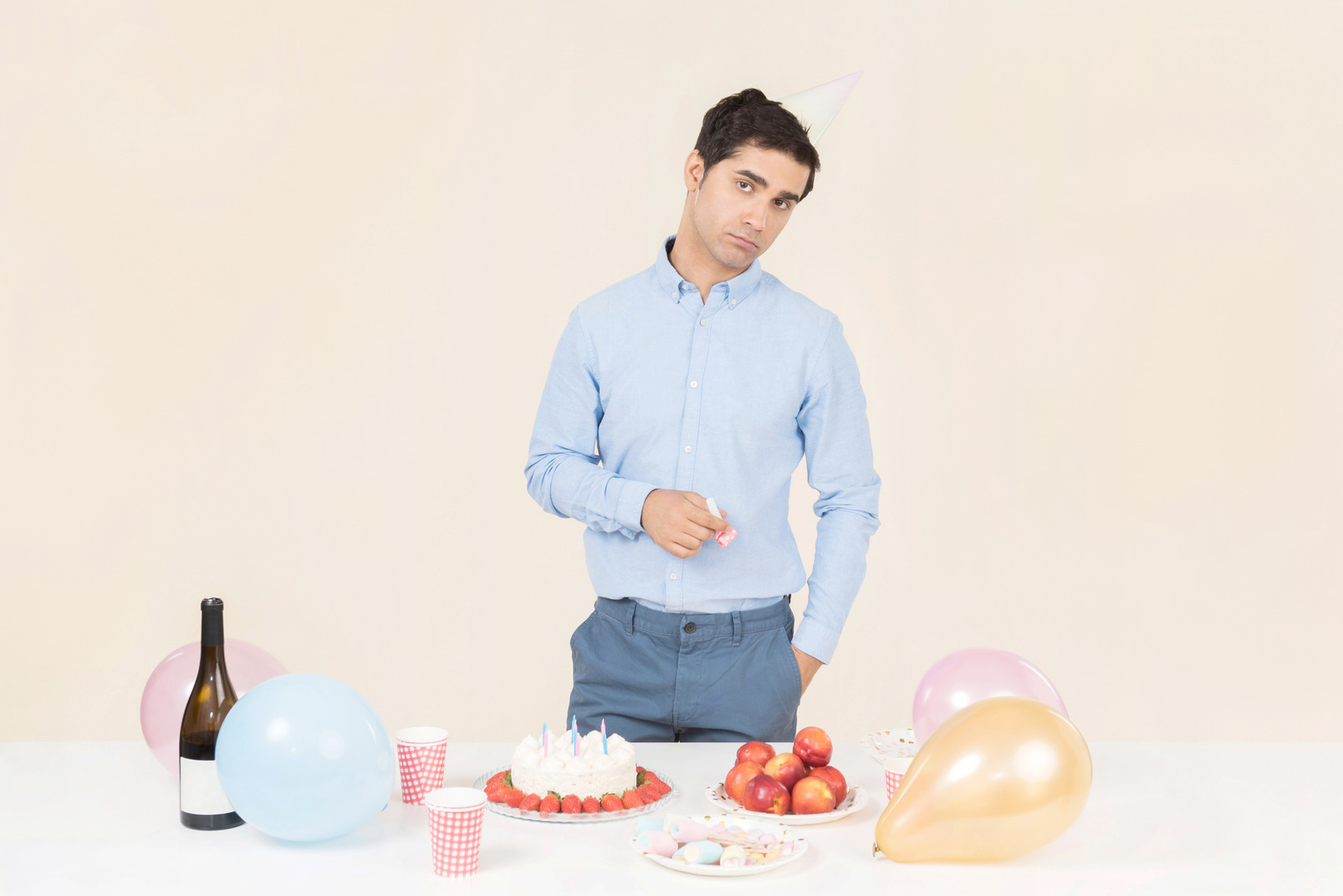 Young caucasian man standing near birthday table