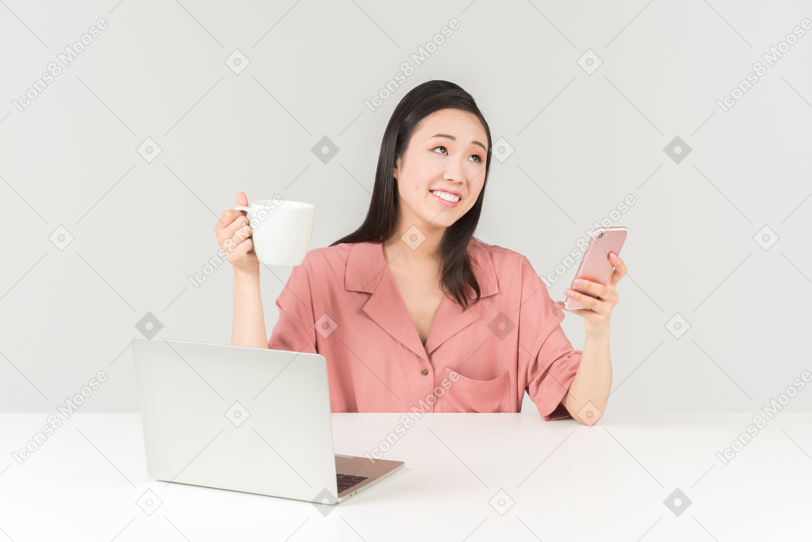 Smiling young asian woman having tea and checking phone
