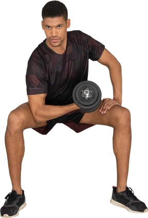 Young man in sports clothes lifting weigths