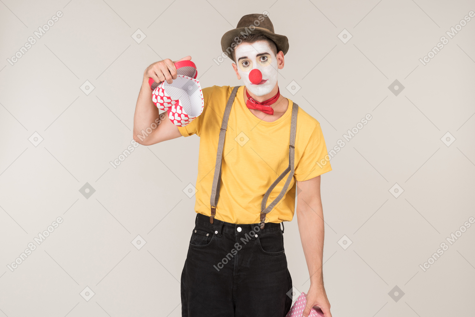 Sad male clown holding empty gift box