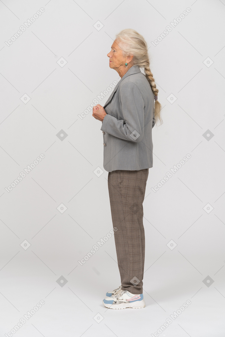 Old lady in suit standing in profile with clenched fists