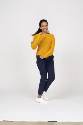 Front view of a happy girl in casual clothes running