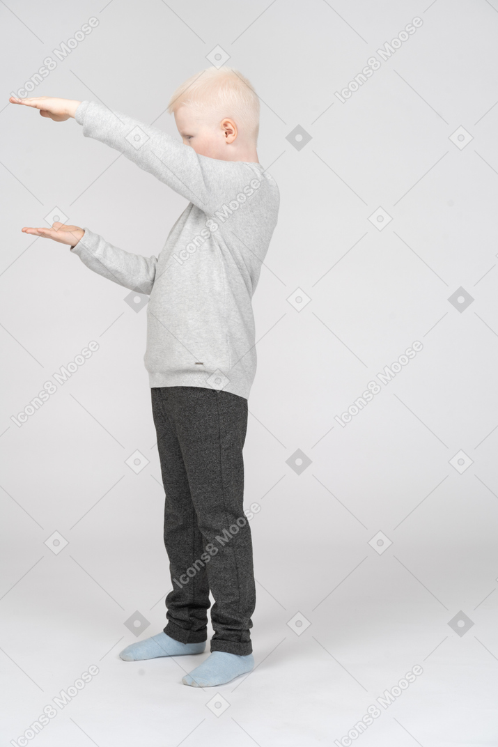 Side view of boy showing size of something with his hands