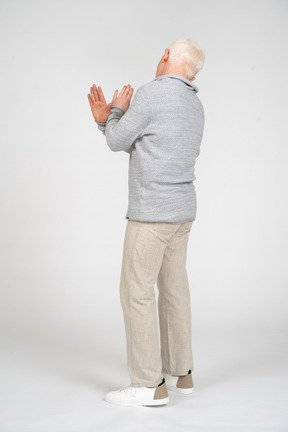Rear view showing enough gesture with hands crossed