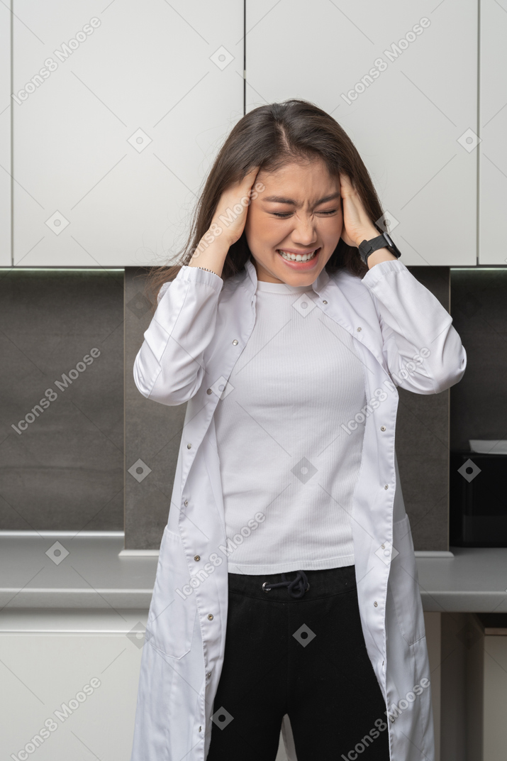 Front view of a female doctor with a headache