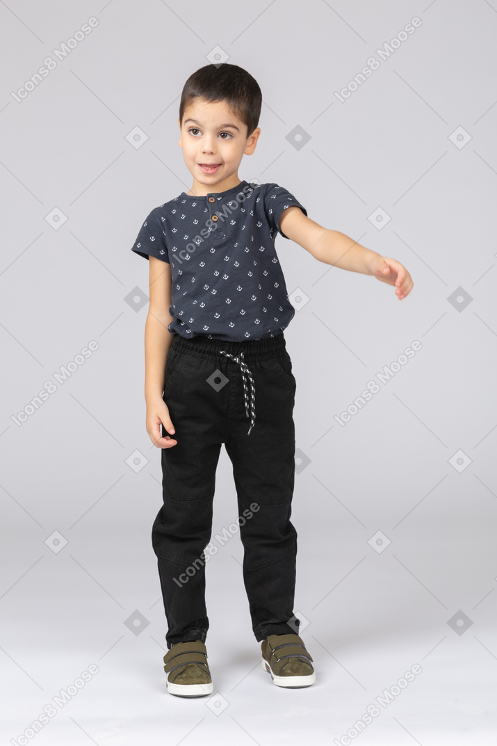 Front view of a cute boy pointing with arm