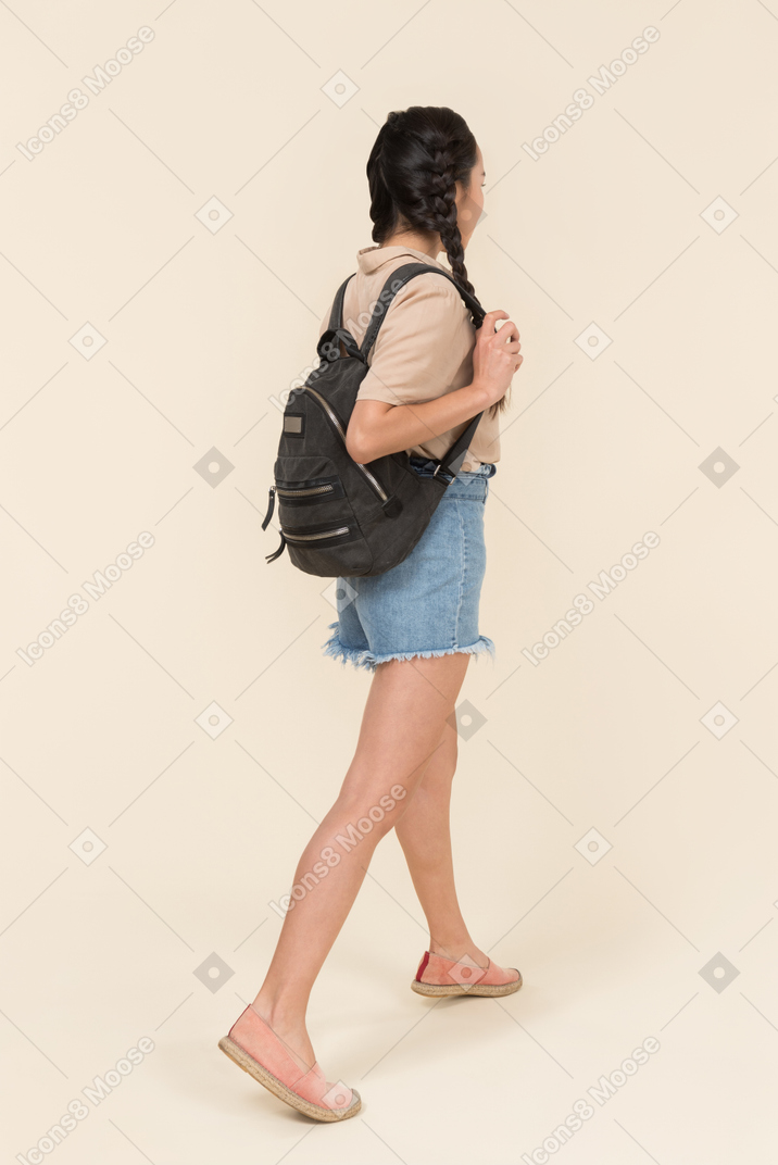 Back view of young woman with backpack
