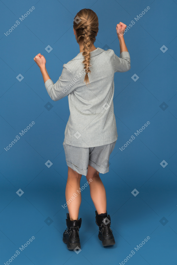 Back view of a young woman celebrating
