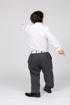 Back view of man in white shirt pointing straight