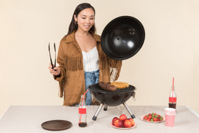 Jovem mulher asiática fazendo churrasco