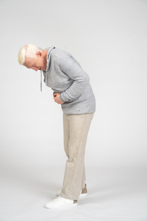 Mann mittleren alters mit händen auf dem bauch, der unter bauchschmerzen leidet