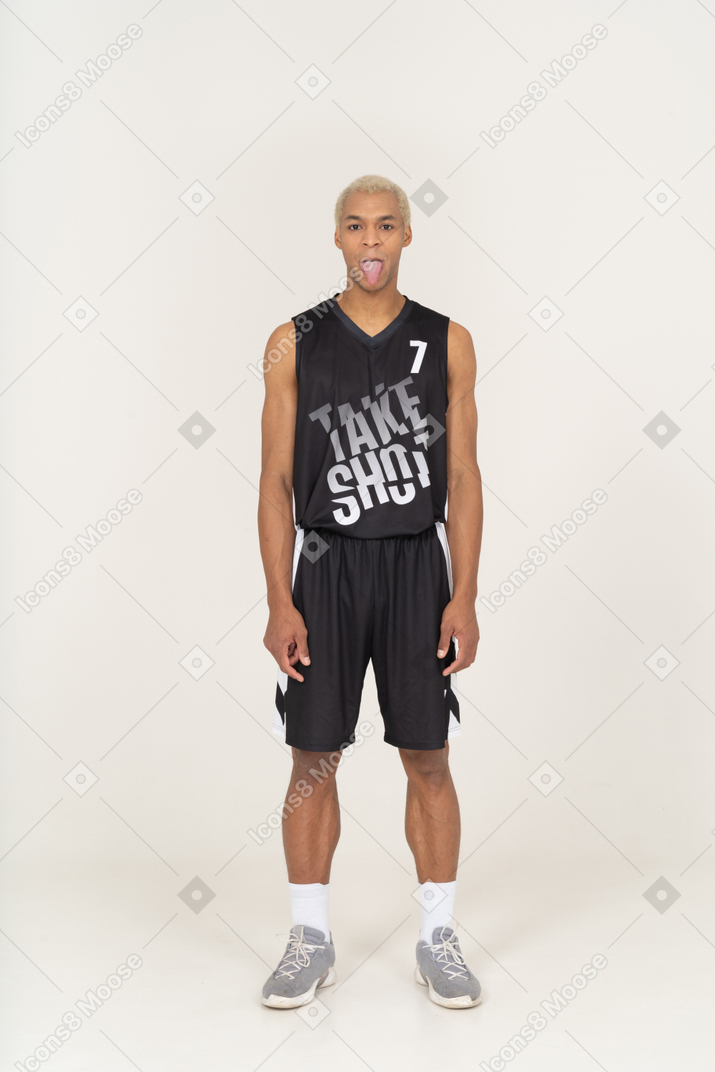 Vista frontale di un giovane giocatore di basket maschile che mostra la lingua