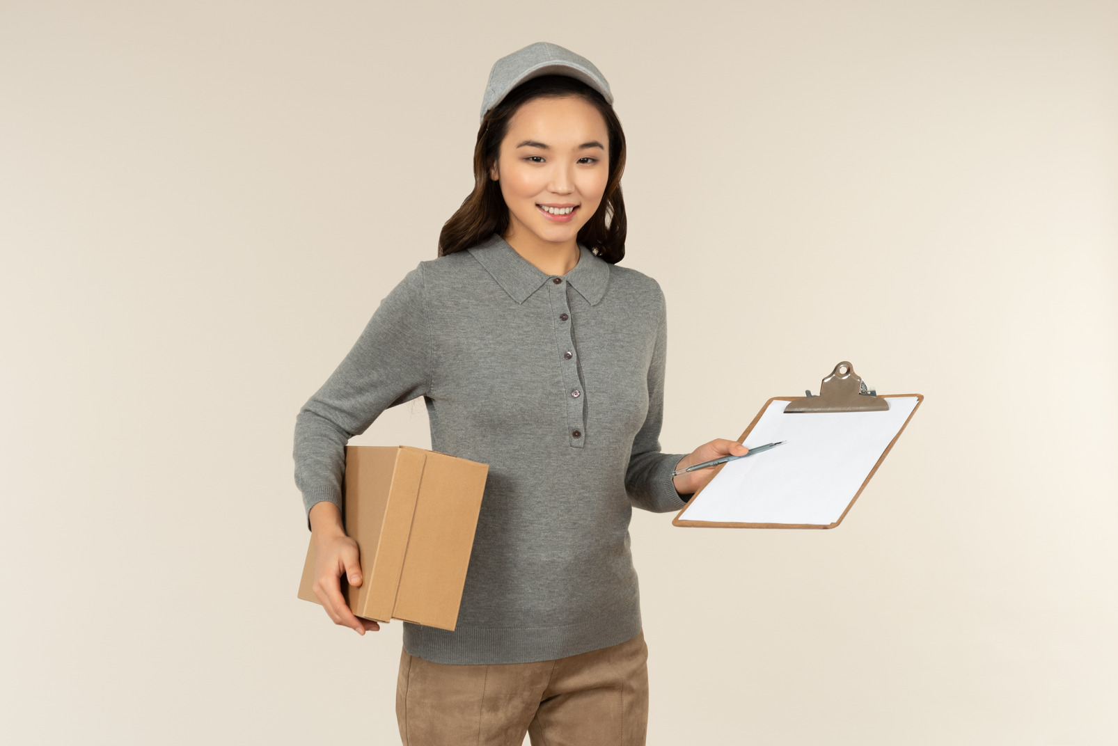 Young asian delivery girl carrying box and folder
