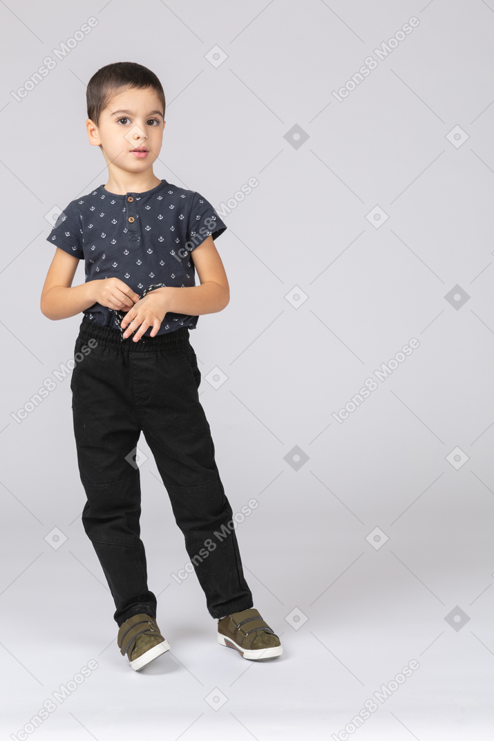 Vue de face d'un garçon mignon dans des vêtements décontractés regardant la caméra