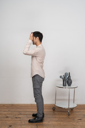 Side view of a man in casual clothes looking through fingers