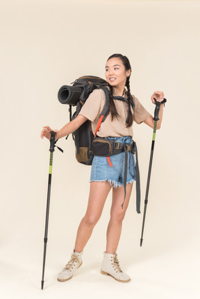 年轻的徒步旅行者女人走路使用登山杆
