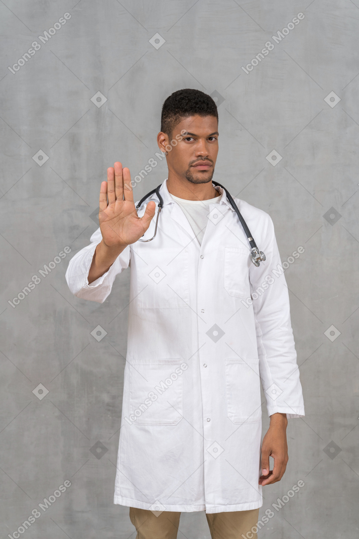 중지 손을 보여주는 남성 의사