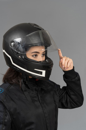 Una motociclista che apre una visiera per casco