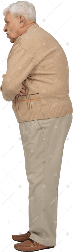 Side view of an old man in casual clothes suffering from stomachache