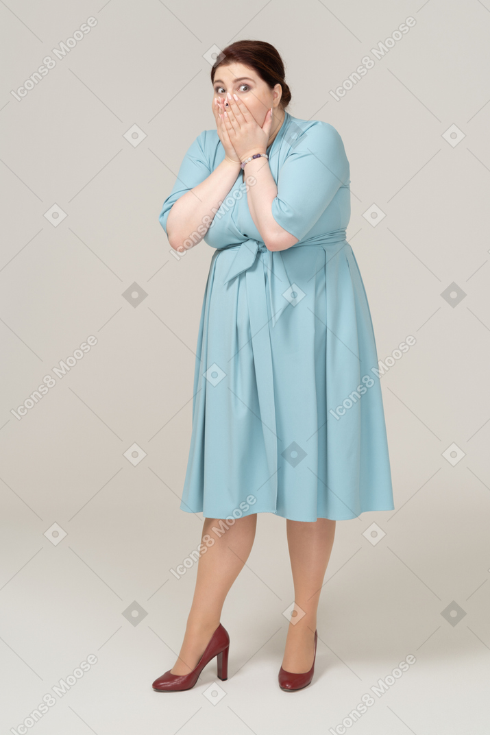 一个穿着蓝色裙子的震惊女人的前视图