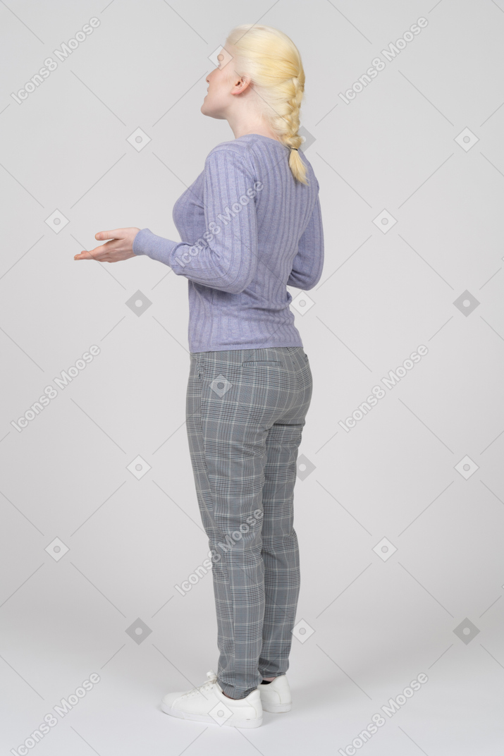 Женщина, объясняющая и жестикулирующая, вид сзади в три четверти