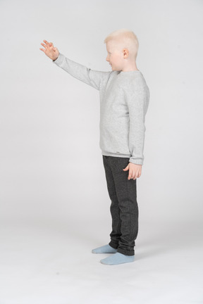 Side view of a boy reaching out for something