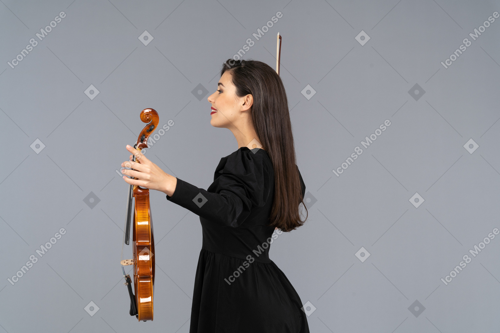 Vue latérale d'une joueuse de violon en robe noire écartant les mains