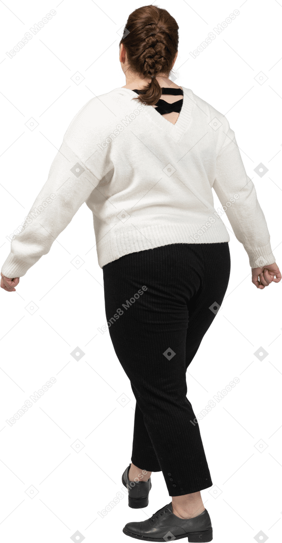 Vista posteriore di una donna grassoccia in abiti casual che cammina