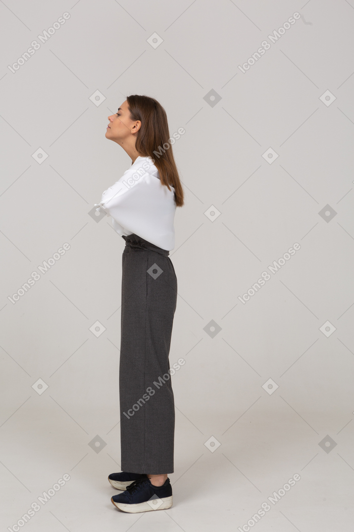 Side view of a young lady in office clothing putting hands on chest