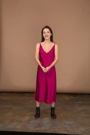 Front view of a happy young woman in beautiful red dress looking at camera