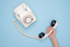 Feminino mão segurando o receptor do telefone vintage