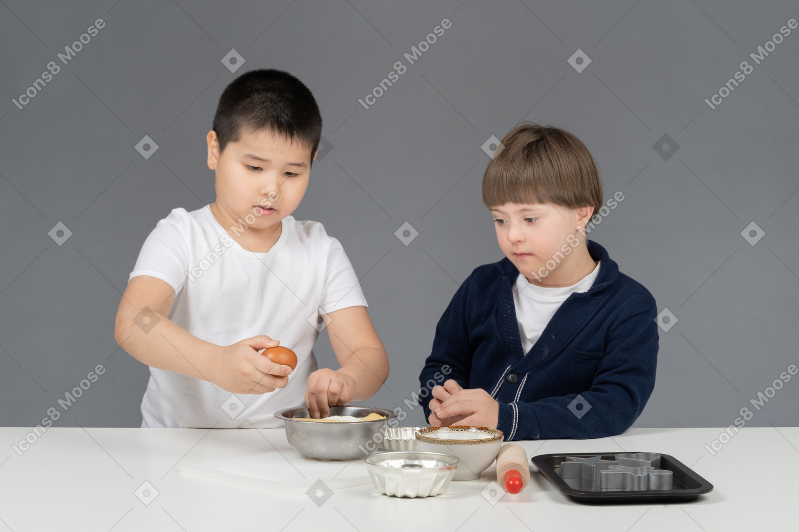 Dos niños pequeños practicando en hornear