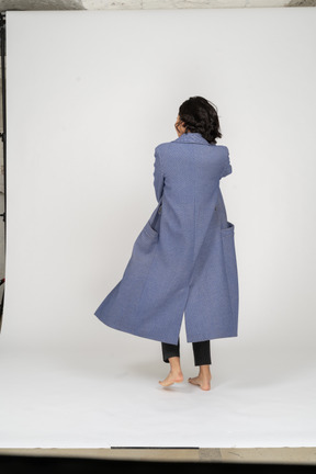 Back view of woman in coat barefoot