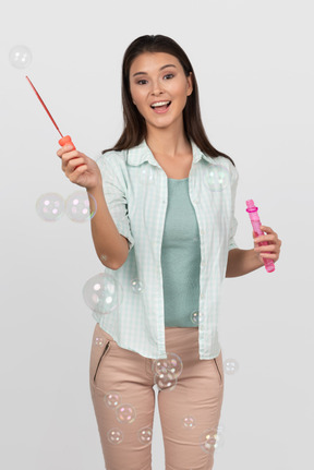 Happy woman blowing soap bubbles