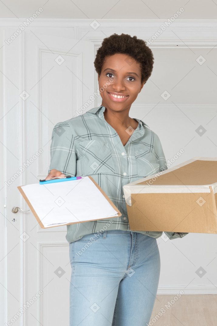 A woman holding a box and a clipboard